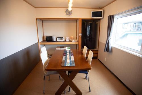 Otaru Village - Vacation STAY 84257 في أوتارو: طاولة طعام وكراسي في غرفة صغيرة