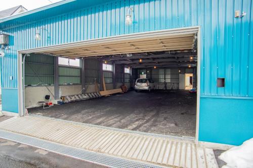 niebieski garaż z samochodem zaparkowanym wewnątrz niego w obiekcie Otaru Village - Vacation STAY 84437 w mieście Otaru