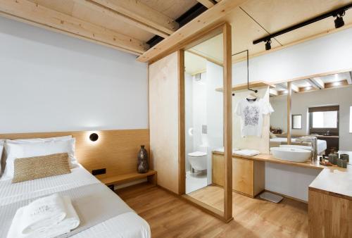 a bedroom with a bed and a bathroom with a sink at Thallos The Boutique in Chania Town