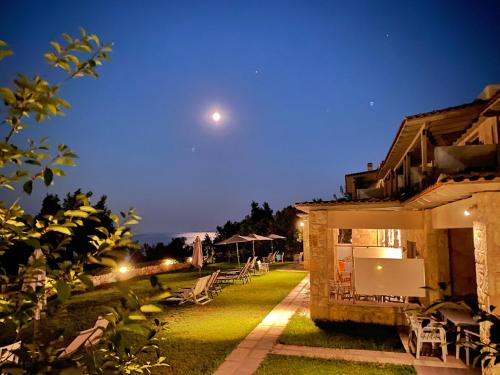 einen Blick auf ein Haus in der Nacht mit dem Mond in der Unterkunft Anatoli Halkidiki in Afytos