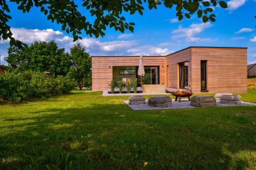 una casa de madera con césped delante en Chalet Seebauer en Neunburg vorm Wald