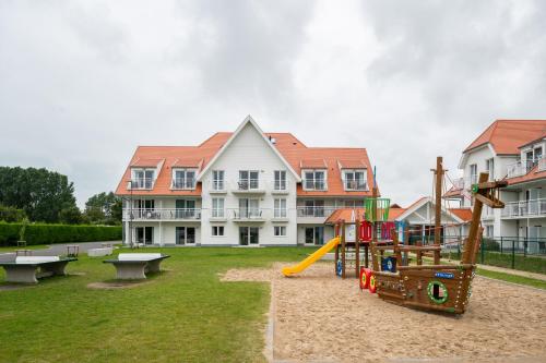 a playground in front of a large building at ibis Styles Nieuwpoort in Nieuwpoort