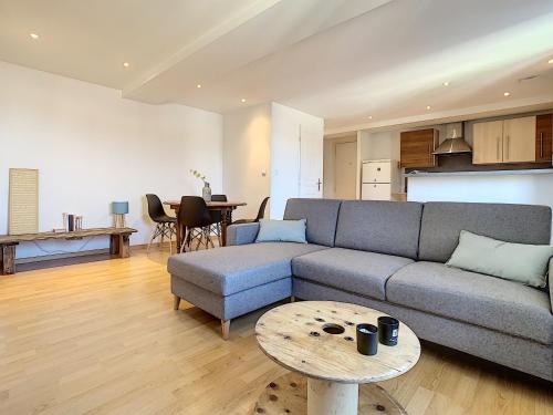 un soggiorno con un divano e un tavolo di Bourgoin-Jallieu Appartement les Augustins a Bourgoin