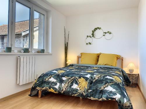 een slaapkamer met een bed en een raam bij Bourgoin-Jallieu Appartement les Augustins in Bourgoin