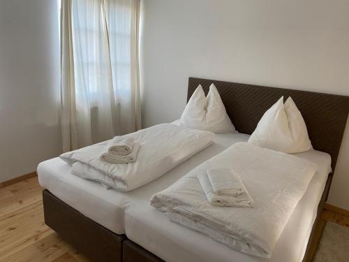 a bed with white sheets and towels on it at ApartMENTZ - 3 Zimmer Apartmenthaus in Sankt Peter ob Judenburg