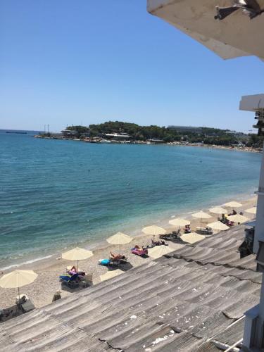 a beach with chairs and umbrellas and the ocean at VOULIAGMENI ON THE BEACH in Athens