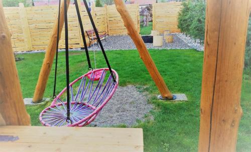 a pink swing in a playground with some baseball bats at Chata Kaprík in Liptovský Mikuláš