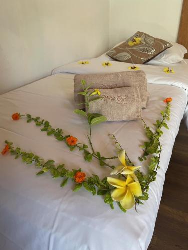 a bed with a flower arrangement on it at RISING SUN BEACH VIEW in Thinadhoo