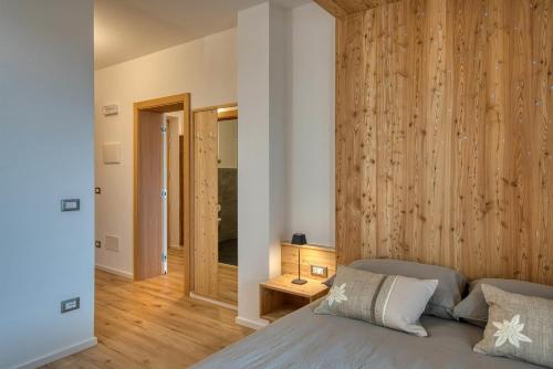 a bedroom with a bed and a wooden wall at Agritur Maso Librar in Trento