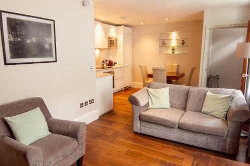 a living room with two chairs and a couch at Tavistock Place Apartments in London