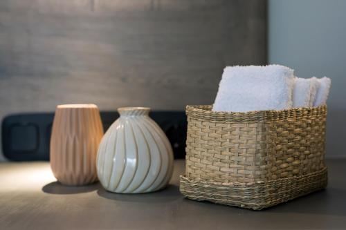 a basket of towels and vases on a table at Kavouri Seaside Luxury Bungalow in Athens
