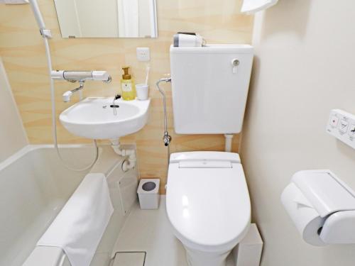 a small bathroom with a toilet and a sink at CHISUN BUDGET Kanazawa Ekimae in Kanazawa