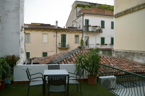 einen Tisch und Stühle auf einem Balkon mit Gebäuden in der Unterkunft Gabrielli Rooms et Apartments Sant Antonio alloggio 4 M0230914084 in Verona