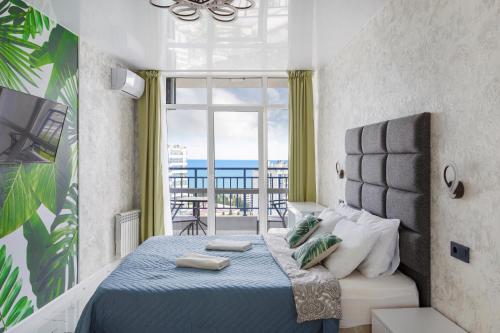 a bedroom with a bed with a view of the ocean at Мандарин in Sochi