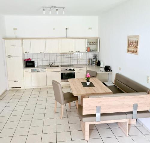 a kitchen with white cabinets and a wooden table at Zum Harzer in Altenau