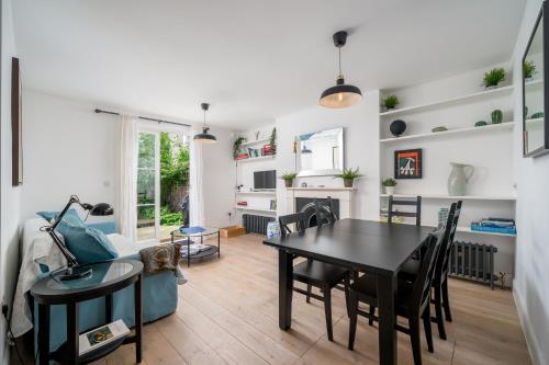 a dining room and living room with a table and chairs at Stylish flat with garden in Notting Hill in London