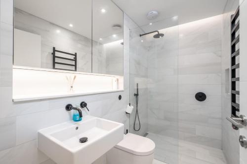 bagno bianco con lavandino e servizi igienici di JOIVY Stylish 2-bed flat with garden in Notting Hill a Londra