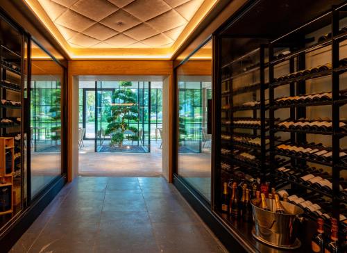a wine cellar with glass doors and a wall of wine bottles at Parkhotel Egerner Höfe in Rottach-Egern