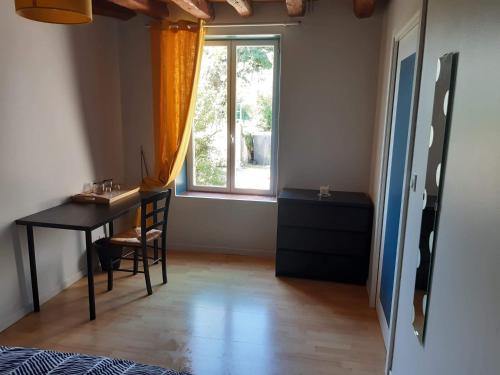 Zimmer mit einem Tisch, einem Fenster und einem Schreibtisch in der Unterkunft Chambre à Ineuil in Ineuil