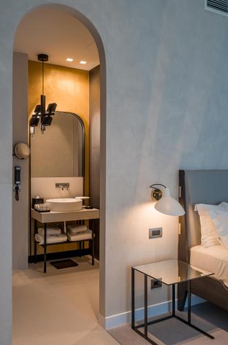 a bathroom with a bed and a sink and a mirror at Monograph Freedom Square in Tbilisi City
