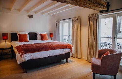 um quarto com uma cama, uma cadeira e uma janela em B&B Anna9 em Bruges