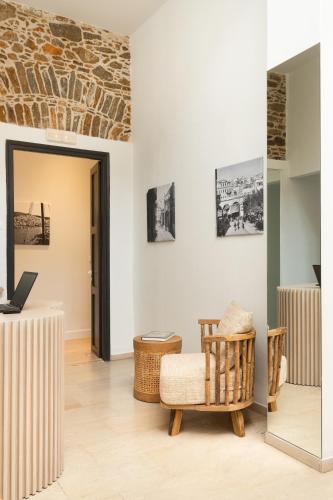 a room with a chair and a laptop on a table at SYROS SOUL LUXURY SUITES in Ermoupoli