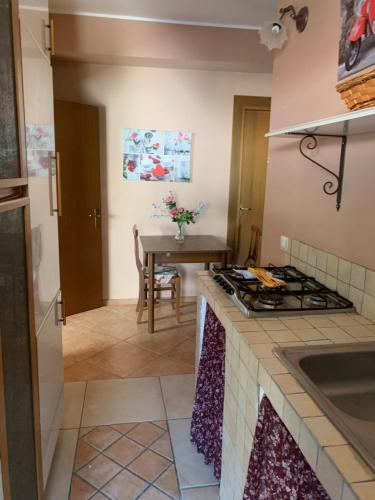 a kitchen with a stove top oven next to a table at Villa Anna! in Castrocielo