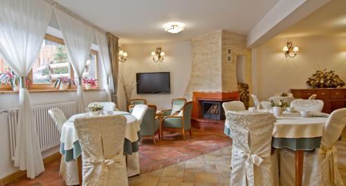 a dining room with tables and chairs and a fireplace at Willa Kominiarski Wierch in Zakopane