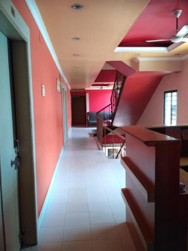 a hallway in a building with red walls and stairs at Omran by WB Inn in Rānchī