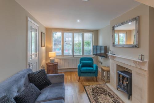 a living room with a couch and a fireplace at Sage Cottage in Atworth