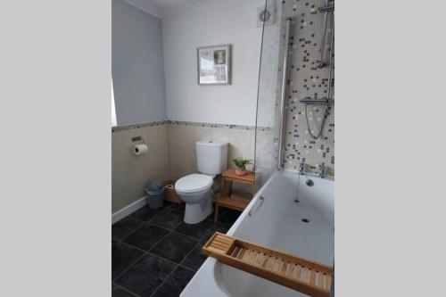 a bathroom with a tub and a toilet at Former Quarryman’s 3-bed house 5 min to Zip World in Bethesda