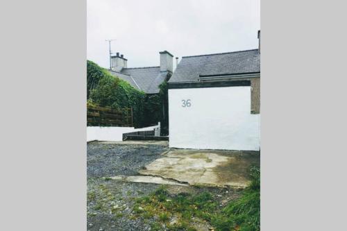 a white garage with the number on it at Former Quarryman’s 3-bed house 5 min to Zip World in Bethesda