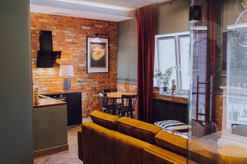 salon z żółtą kanapą i kuchnią w obiekcie Apartamenty Zamkowe Centrum w mieście Kwidzyn