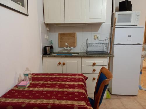 una pequeña cocina con mesa y nevera blanca en צימר בודד בגליל העליון en Kefar Szold