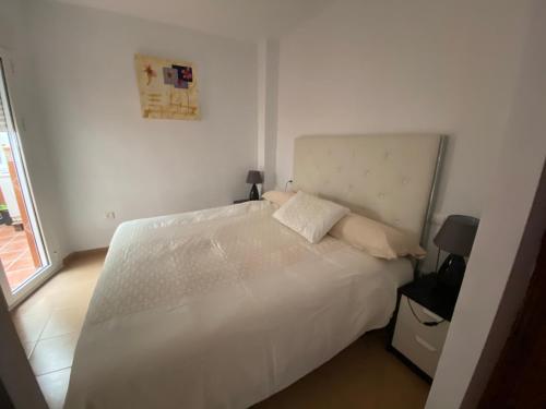 フエンヒロラにあるApartamento Fuengirola centroの白いベッドルーム(窓付)の白いベッド1台