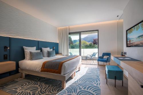 a hotel room with a bed and a large window at Rivage Hôtel & Spa Annecy in Annecy