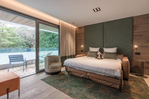 a bedroom with a bed with a teddy bear on it at Rivage Hôtel & Spa Annecy in Annecy