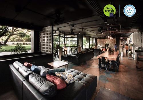 a living room with a couch and a table at the echo hotel in Chiang Mai