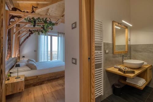 a bathroom with a sink and a bed with a window at Agritur Maso Librar in Trento