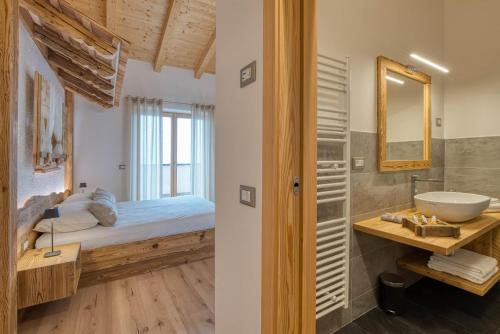 a bathroom with a bed and a sink and a mirror at Agritur Maso Librar in Trento
