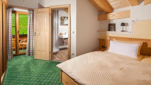 拉姆紹的住宿－Kainzierlhof Ferienwohnung，一间卧室设有一张床,并铺有绿色地板。