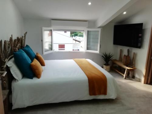 Un dormitorio con una gran cama blanca y una ventana en Appartement au dessus de la maison du Saunier en Salin-de-Giraud