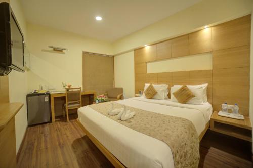 a hotel room with two beds and a television at Coraltree By Goldfinch Hotels Bangalore in Bangalore