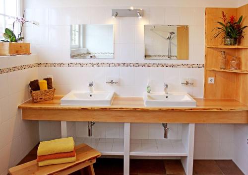 La salle de bains est pourvue de 2 lavabos et d'un miroir. dans l'établissement Ferienhaus Villa Maria / Ferienwohnung Chippendale, à Gohrisch