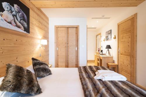a bedroom with a large bed with wooden walls at La Ferme Du Lac in Thyez