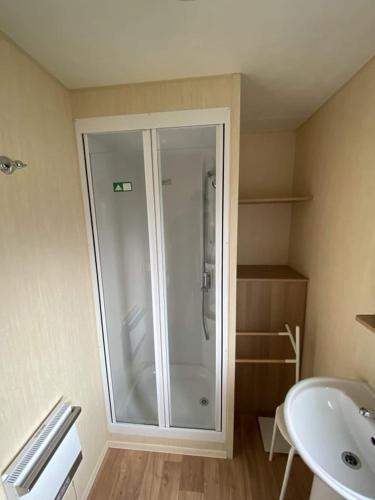 a bathroom with a shower and a sink at 8 BERTH CARAVAN PG30 in Chapel Saint Leonards