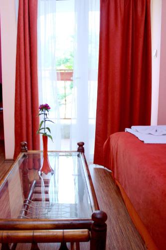 a bedroom with a glass table with a vase with flowers on it at Family Hotel Flora in Zlatograd