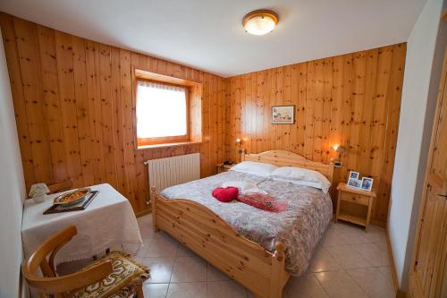 Un dormitorio con una cama y una mesa. en Chalet Bucaneve en Santa Caterina Valfurva