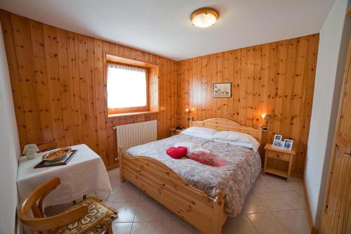 サンタ・カテリーナ・ヴァルフルヴァにあるChalet Bucaneveのベッドルーム(ベッド1台、テーブル付)