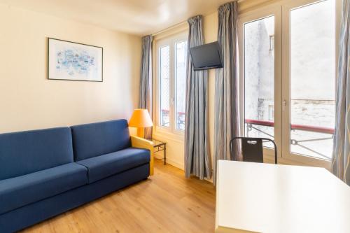 パリにあるHôtel Capfun Le Saint Germain, Parisの青いソファとテーブルのあるリビングルーム